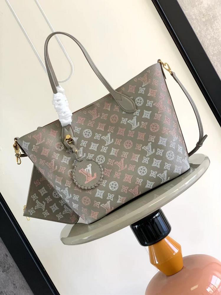 The M23387 gray screen printed Blossom medium tote bag is made of lightweight carved cowhide leather and features a perforated Monogram pattern on top