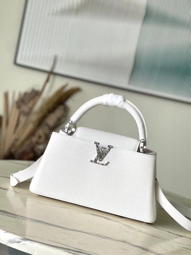 M24671 white mediumThis Capucines East West medium handbag is from the LVCrush collection featuring a grain cowhide leather body illuminated by the L