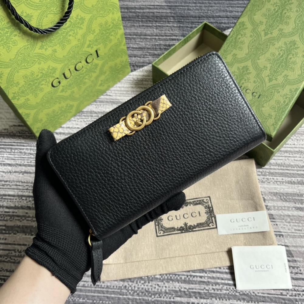 This long wallet comes with a complete set of packaging and is made of black leather The front bow is crafted with python skin rolled edges and gol