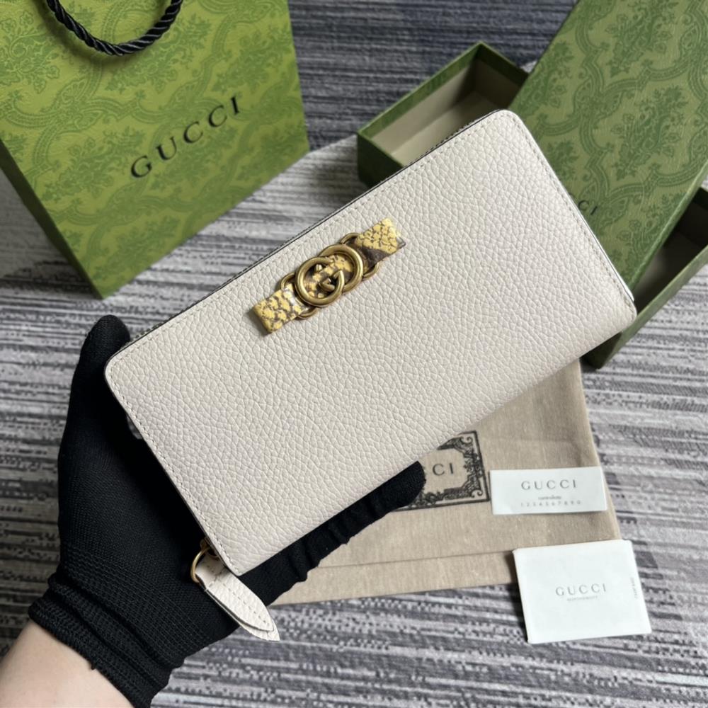 This long wallet comes with a complete set of packaging and is made of refined white leather The front bow is crafted with python skin rolled edges