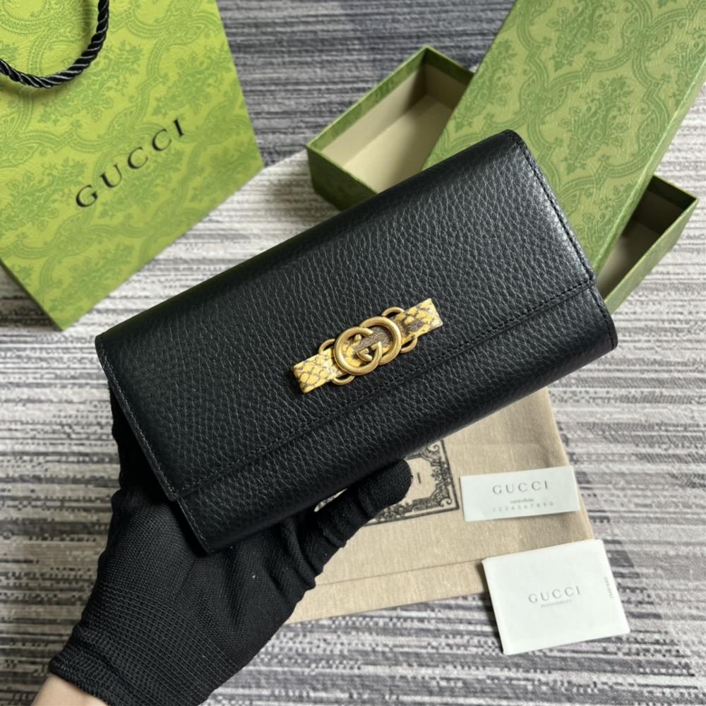 This long wallet comes with a complete set of packaging and is made of black leather The front bow is crafted with python skin rolled edges and gol