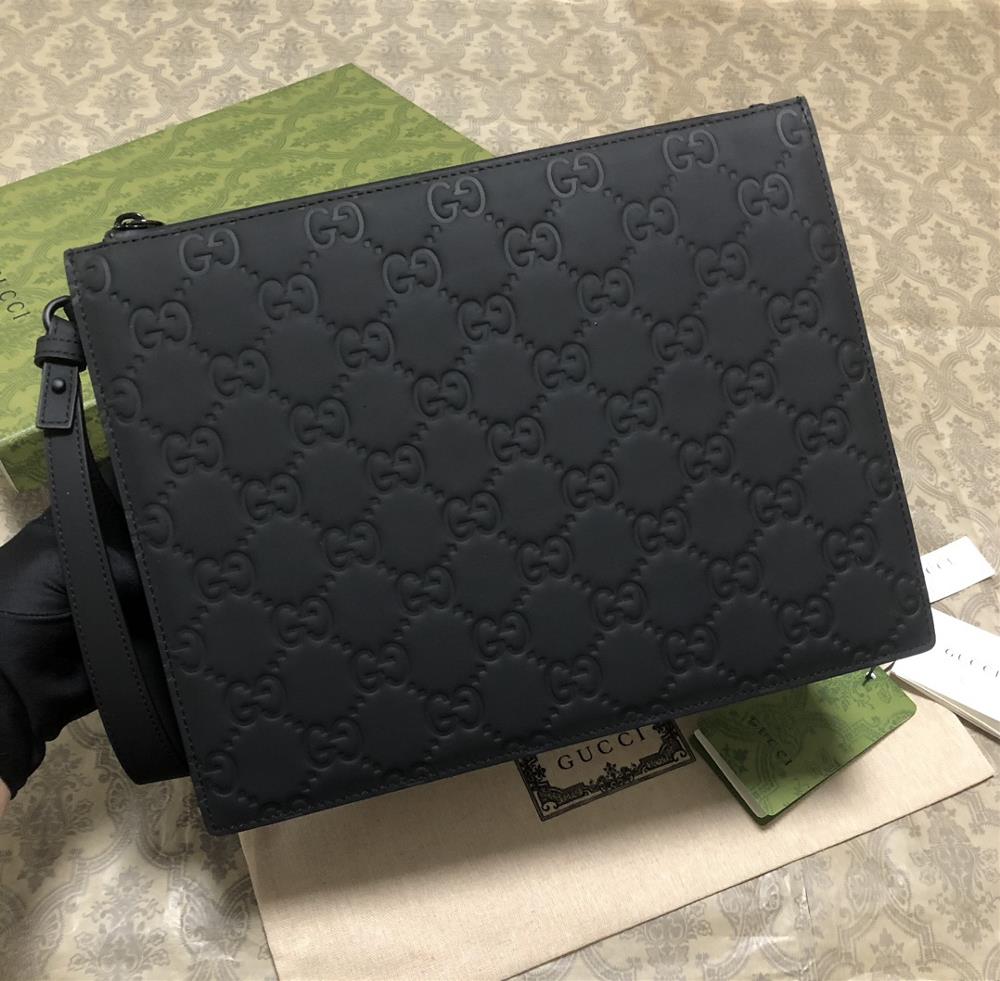 A mens handbag made of black rubber effect leather has made a dazzling debut and the new material brings a new visual highlight to this fashionable