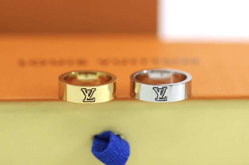 Louis Vuitton letter printed gold and silver couple ringThe LV Catch ring is intricately carved with LV letters and Monogram flowers witnessing Louis