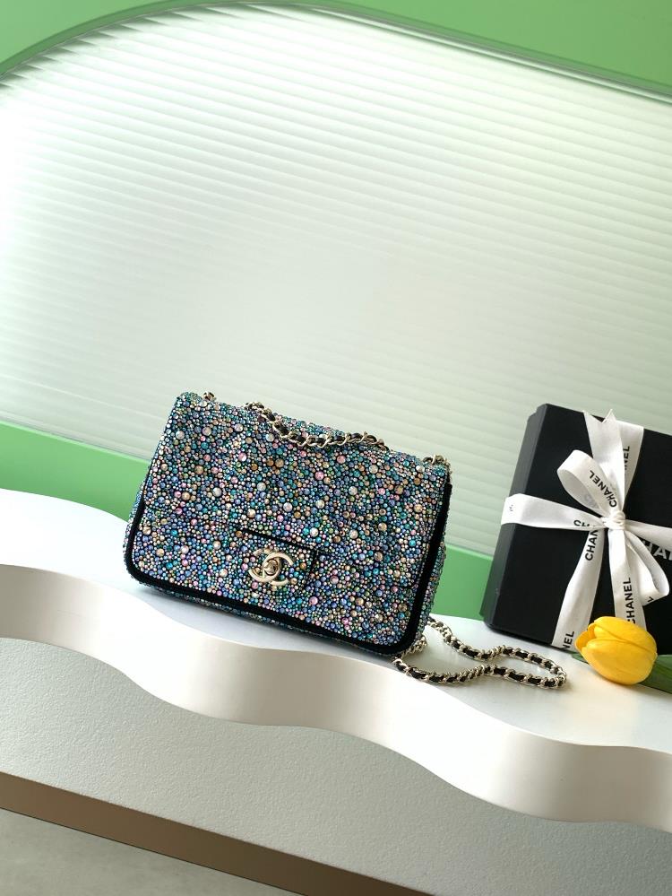 The 26C SAC DU SOIR dinner bag features colorful rhinestones on a black background a luxurious gold metal chain shoulder strap and a classic double