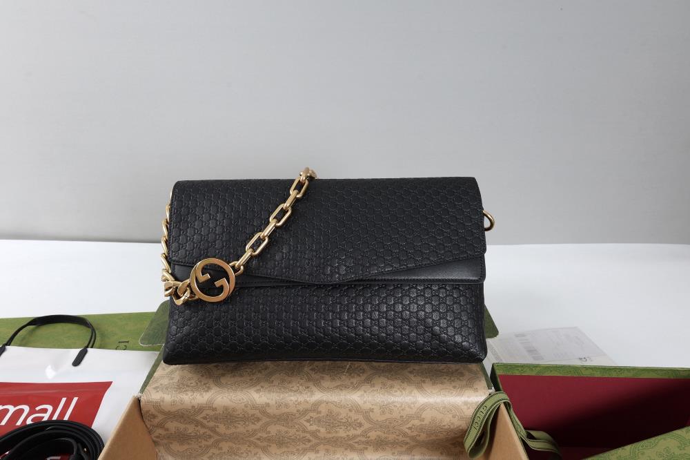 This handbag combines a modern silhouette with the brands iconic pattern This sleek cut handbag is paired with a gold toned chain adorned with circu